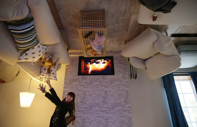 A visitor poses inside an upside-down house created by a group of Taiwanese architects at the Huashan Creative Park in Taipei, Taiwan, Tuesday, February 23, 2016. (Photo by Wally Santana/AP Photo)
