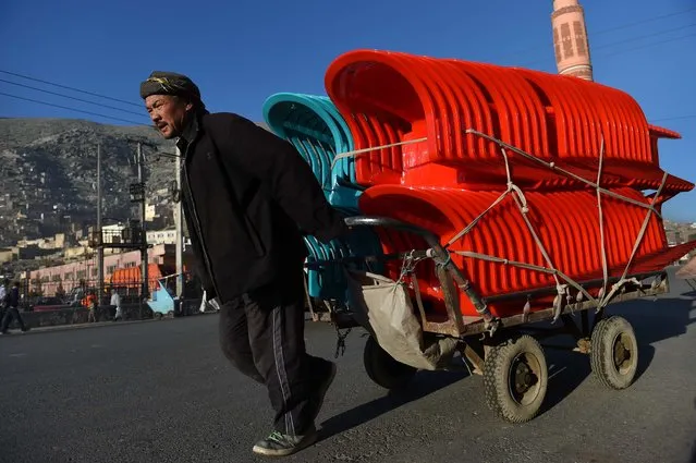 An Afghan laborer pull his carts loaded with plastic chairs along a street in Kabul on April 8, 2015. (Photo by Wakil Kohsar/AFP Photo)