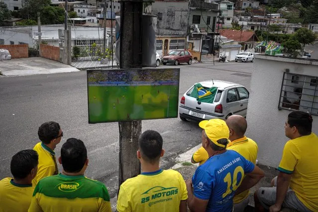 Fans watch Brazil's World Cup match against Serbia on a television fixed to a light pole, in Manaus, Brazil, 24 November 2022. Brazil won the match 2-0. (Photo by Raphael Alves/EPA/EFE)