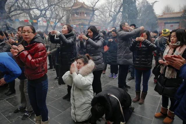 People burn incense sticks and pray for good fortune at Yonghegong Lama Temple on the first day of the Lunar New Year of the Rooster in Beijing, China January 28, 2017. (Photo by Damir Sagolj/Reuters)