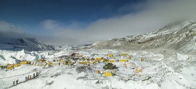 A rescue helicopter is shown at the Mount Everest south base camp in Nepal a day after a huge earthquake-caused avalanche killed at least 17 people, in this photo courtesy of 6summitschallenge.com taken on April 26, 2015 and released on April 27, 2015. Rescue teams, helped by clear weather, used helicopters to airlift scores of people stranded at higher altitudes, two at a time. (Photo by Reuters/6summitschallenge.com)