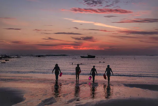 Sea swimmers emerge before dawn from the waters of the North Sea at Cullercoats Bay, between Tynemouth and Whitley Bay, on the north east coast of England on Friday, September 17, 2021. (Photo by Owen Humphreys/PA Images via Getty Images)