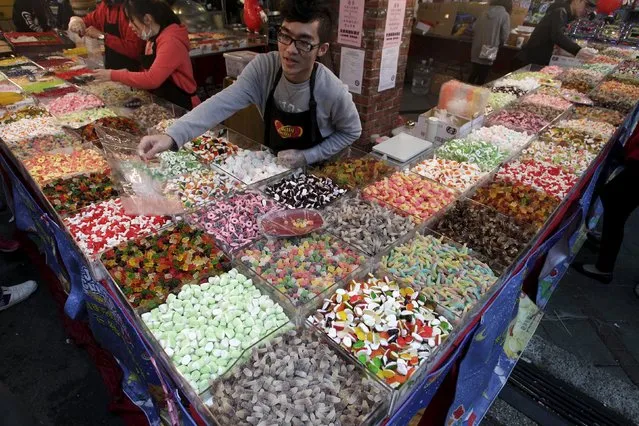 A shop attendant sells candies in a shop selling Chinese New Year goods at a market in Taipei, Taiwan, in this February 3, 2016 file photo. (Photo by Pichi Chuang/Reuters)