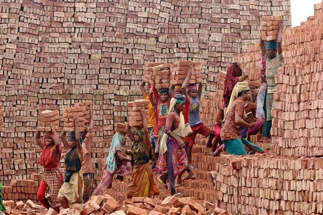 Bangladeshi migrants holds bricks blocks over his head to transport it on the other side of the river at a brick-field in Keraniganj on September 4, 2021. Around 400,000 low-income migrants arrive in Dhaka every year to work at brickfields, In the brick factory Millions of bricks are burned even though this affects the environment in Bangladesh. laborer pulling a cart loaded with bricks ready to be burnt at Keraniganj brick field. Brick field laborers work 7days a week and get BDT 350 (4.37 USD) per day. (Photo by Habibur Rahman/ZUMA Press Wire Service/Rex Features/Shutterstock)