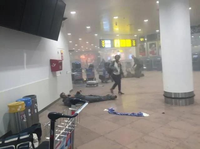 In this photo provided by Georgian Public Broadcaster and photographed by Ketevan Kardava a man is wounded in Brussels Airport in Brussels, Belgium, after explosions were heard Tuesday, March 22, 2016. A developing situation left a number dead in explosions that ripped through the departure hall at Brussels airport Tuesday, police said. All flights were canceled, arriving planes were being diverted and Belgium's terror alert level was raised to maximum, officials said. (Photo by Ketevan Kardava/ Georgian Public Broadcaster via AP Photo)