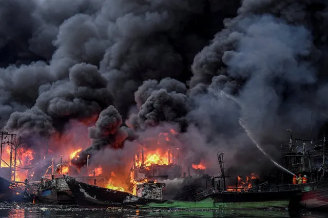 Firefighters try to extinguish the fire burning fishing boats at Muara Baru port in Jakarta, Indonesia, February 23, 2019 in this photo taken by Antara Foto. (Photo by Hafidz Mubarak A./Antara Foto via Reuters)