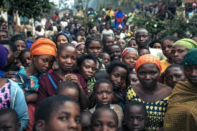 Dozens of war-displaced people stand in the courtyard of an elementary school where they have taken refuge in Minova, South Kivu province, in the East of the Democratic Republic of Congo, on March 9, 2024. In early February, M23 rebels, backed by the Rwandan army, took control of the road linking Goma, capital of North Kivu, to Minova and Bukavu, causing the Congolese army to flee to Minova as well as tens of thousands of civilians. The only remaining access route to Minova is via Lake Kivu. Humanitarian aid for the nearly 300,000 displaced people in Minova is almost inexistent. In Eastern DRC, over 1.5 million people are displaced by the advance of the M23, which took up arms again at the end of 2021. (Photo by Alexis Huguet/AFP Photo)