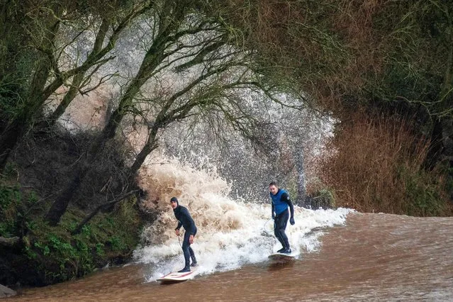 Surfers on March 12, 2024 in Minsterworth, Gloucestershire ride the Severn Bore, a wave generated by the Atlantic Ocean entering the Bristol Channel and forcing its way into the Severn Estuary. As it nears this narrow section, the water speeds up and creates a wave as the surface of the water travels faster than the base. (Photo by Lee Thomas/The Times)