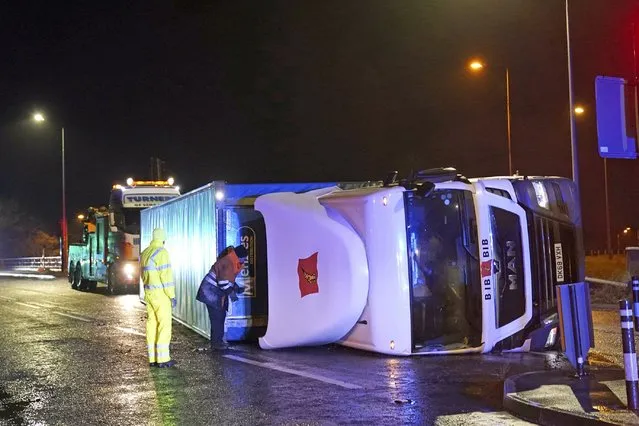 A truck lies on its side after being blown over by gusts of wind of almost 100 miles (160 km) per hour which battered some areas of the country during Storm Arwen, in Hartlepool, England, early Saturday November 27, 2021. The Met Office issued a rare red warning for wind from 3pm on Friday to 2am on Saturday as the first winter storm was set to batter the country. (Photo by Owen Humphreys/PA Wire via AP Photo)