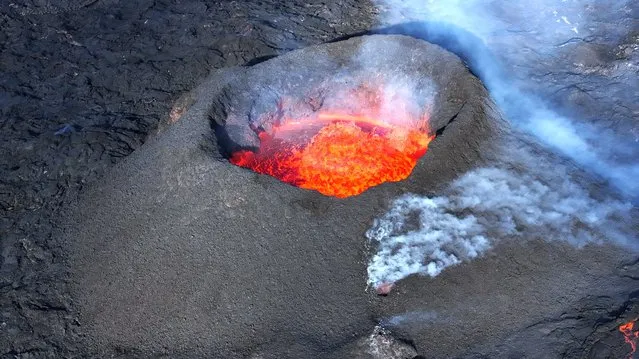 Picture taken with a drone on April 13, 2024 at Svartsengi near Grindavik, Iceland, shows an aerial view of a volcanic eruption at Sundhnukagigar in southwest Iceland, ongoing for a month. (Photo by Jeremie Richard/AFP Photo)