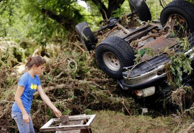 Jamie Myers looks for a neighbor's antiques that were washed into West Cache Creek bed after flooding in Cache, Okla., Sunday, May 24, 2015. (Photo by Sarah Phipps/The Oklahoman via AP Photo)