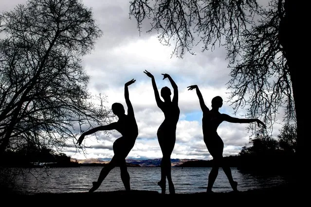 Scottish Ballet dancers Seira Winning Urara Takata and Danila Marzilli dance on the banks of Loch Lomond ahead of the Swan Lake tour, which opens in Glasgow next week then tours to Aberdeen, Inverness and Edinburgh, near Glasgow, in Scotland on March 26, 2024. (Photo by Lesley Martin/Reuters)