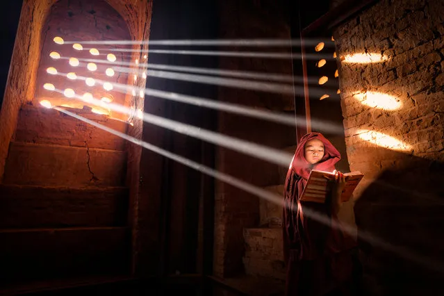 “Light Source”. Young Monk finds a perfect light source to read his book inside of his pagoda – Old Bagan, Burma. Photo location: Old Bagan. (Photo and caption by Marcelo Castro/National Geographic Photo Contest)