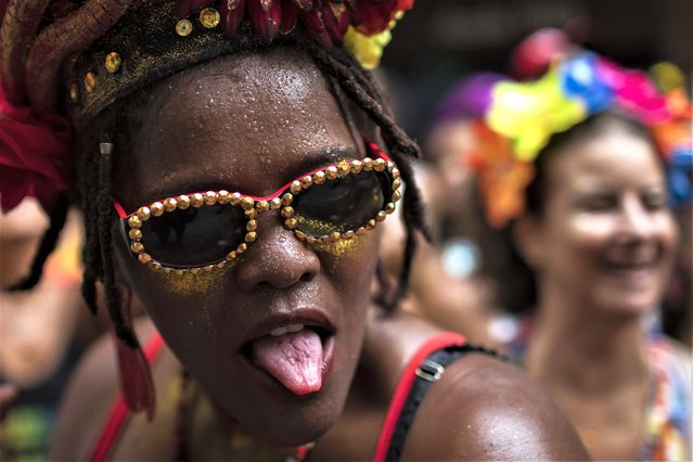 A reveler playfully sticks out her tongue during a street pre-carnival party by the “Cordao do Boitata” Block, in Rio de Janeiro, Brazil, Sunday, February 12, 2023. Revelers are taking to the streets for the open-air block parties, leading up to Carnival's official Feb. 17th opening. (Photo by Bruna Prado/AP Photo)
