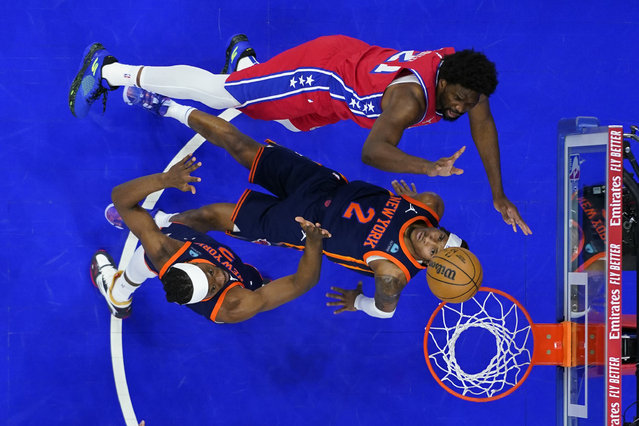 Philadelphia 76ers' Joel Embiid, top, goes up for a shot against New York Knicks' Miles McBride, center, and Precious Achiuwa during the first half of Game 4 in an NBA basketball first-round playoff series, Sunday, April 28, 2024, in Philadelphia. (Photo by Matt Slocum/AP Photo)