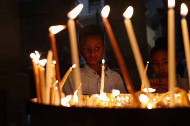 Children look at the candles inside the Church of the Holy Sepulchre on the day Orthodox Christian worshippers attend a Good Friday procession along the Via Dolorosa in Jerusalem's Old City, on May 3, 2024. (Photo by Shannon Stapleton/Reuters)