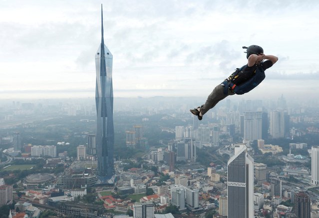 A base jumper leaps off the Kuala Lumpur Tower during the annual KL Tower International Jump Malaysia 2023 in Kuala Lumpur, Malaysia on February 3, 2023. (Photo by Hasnoor Hussain/Reuters)
