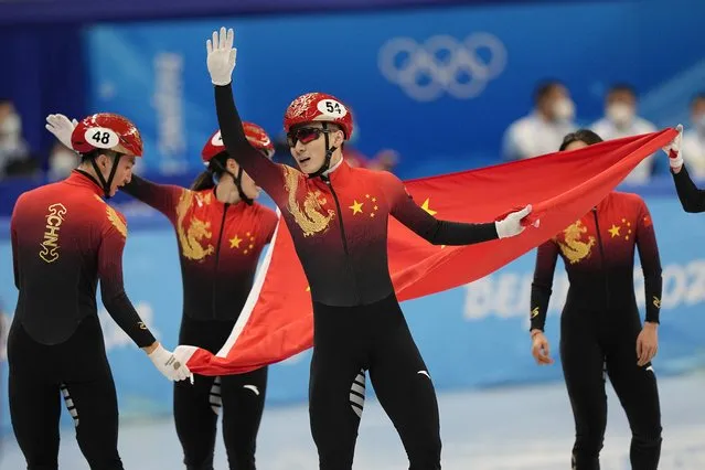 Ren Ziwei of China celebrates with teammates after they won the mixed team relay final during the short track speedskating competition at the 2022 Winter Olympics, Saturday, February 5, 2022, in Beijing. (Photo by David J. Phillip/AP Photo)