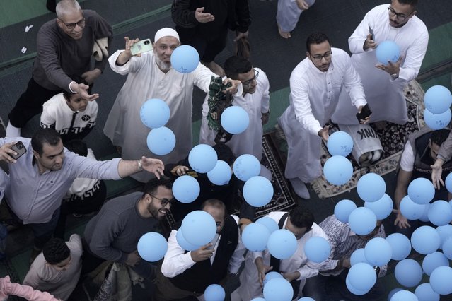 Muslims try to catch free balloons distributed during Eid al-Fitr, marking the end of the Muslim holy fasting month of Ramadan, outside al-Seddik mosque in Cairo, Egypt, Wednesday, April 10, 2024. (Photo by Amr Nabil/AP Photo)