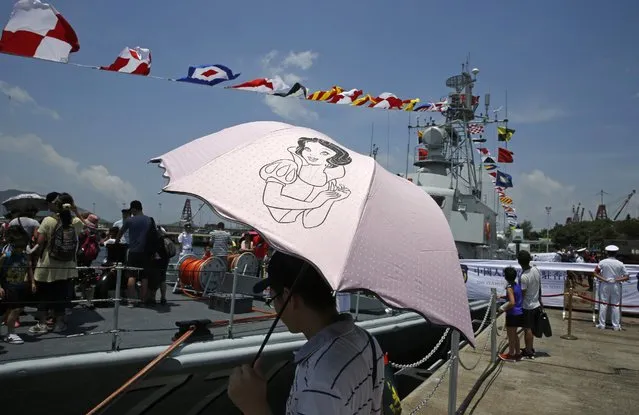 Visitors walk on a naval ship during the open day of Stonecutter Island Navy Base of Chinese People's Liberation Army (PLA) in Hong Kong to mark the 18th anniversary of the Hong Kong handover to China in Hong Kong, Wednesday, July 1, 2015. (Photo by Kin Cheung/AP Photo)