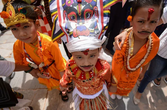 A Nepali child (C) dressed in a traditional cow costume poses with others as they take part in a procession for the Gai Jatra cow festival in Kathmandu on August 16, 2019. The annual Gai Jatra festival, which dates back to the 17th century, pays respects to those who have died in the past year, with families staging colourful processions through town centres. These are traditionally led by a cow or by young men dressed with headgear depicting a cow. (Photo by Prakash Mathema/AFP Photo)