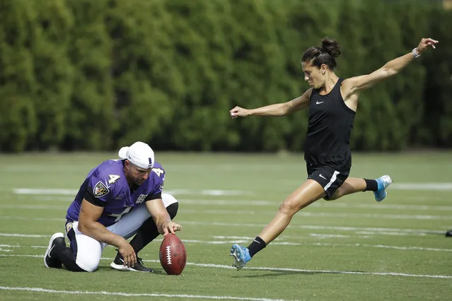 Baltimore Ravens' Sam Koch holds the ball for United States soccer player Carli Lloyd as she attempts to kick a field goal after the Philadelphia Eagles and the Baltimore Ravens held a joint NFL football practice in Philadelphia, Tuesday, August 20, 2019. (Photo by Matt Rourke/AP Photo)