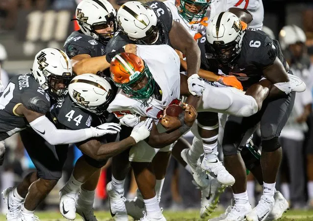 Florida A&M running back Terrell Jennings (23) is lifted off the ground and tackled by five Central Florida defensive players during the first half of an NCAA college football game Thursday, August 29, 2019, in Orlando, Fla. (Photo by Willie J. Allen Jr./AP Photo)