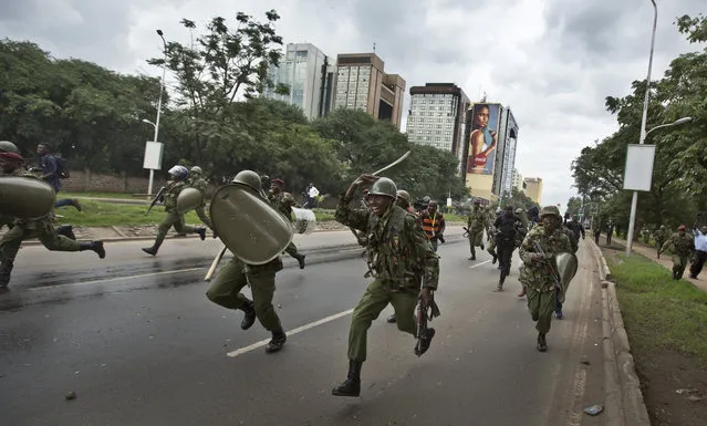 Riot policeman charge towards opposition supporters during a protest in Nairobi, Kenya Monday, May 9, 2016. (Photo by Ben Curtis/AP Photo)