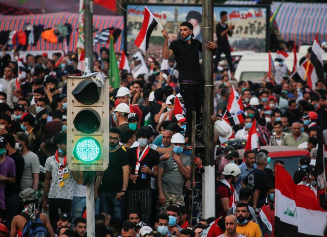 A green traffic light is seen as demonstrators take part in a protest over corruption, lack of jobs, and poor services, in Baghdad, Iraq on October 29, 2019. (Photo by Wissm al-Okili/Reuters)