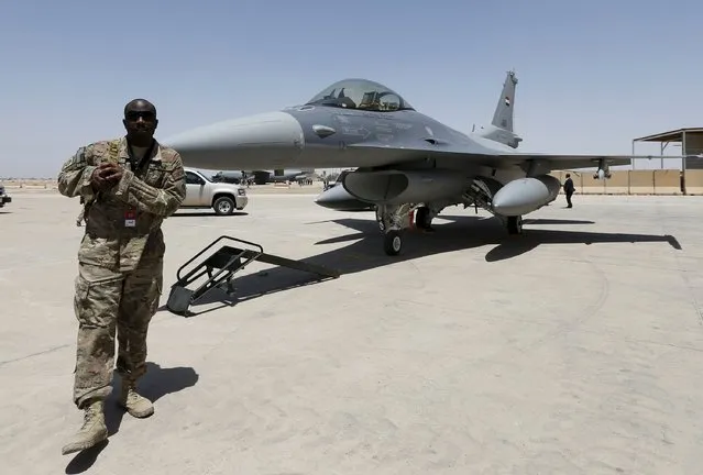 A U.S. Army soldier walks near a F-16 fighter jet during an official ceremony to receive four of these aircrafts from the U.S., at a military base in Balad, Iraq, July 20, 2015. (Photo by Thaier Al-Sudani/Reuters)