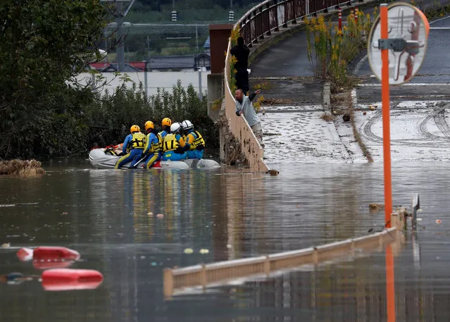 A man talks with rescue workers searching a flooded area in the aftermath of Typhoon Hagibis, which caused severe floods at the Chikuma River in Nagano, Nagano Prefecture, Japan, October 14, 2019. (Photo by Kim Kyung-Hoon/Reuters)