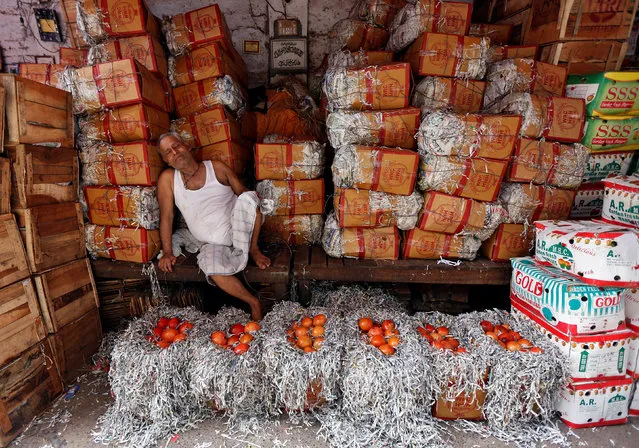 A vendor takes a nap at his shop on a hot summer day at a wholesale fruit market in Kolkata, India, May 17, 2017. (Photo by Rupak De Chowdhuri/Reuters)