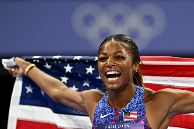 Gabrielle Thomas of the United States celebrates with her national flag after winning gold in the women's 200-meter event at the Paris Olympics on Aug. 6, 2024, at Stade de France in Saint-Denis, near Paris. (Photo by Dylan Martinez/Reuters)