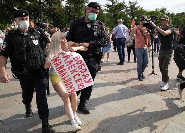 In this August 14, 2021, file photo, Russian police detain an opposition activist with a poster reading “Freedom to Alexei Navalny” during an anti-vaccination protest in the center of Moscow, Russia. Imprisoned Russian opposition leader Navalny and his embattled allies won't be running in the Sept. 19 parliamentary election, but they still hope to challenge the ruling United Russia party with their strategy known as Smart Voting. (Photo by Alexander Zemlianichenko/AP Photo/File)