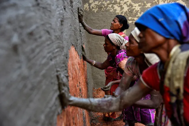 Labourers coat bricks with a mixture of mud and cow dung in a brick kiln at Langolpota village in North 24 Parganas district in the eastern state of West Bengal, India, November 26, 2019. (Photo by Ranita Roy/Reuters)