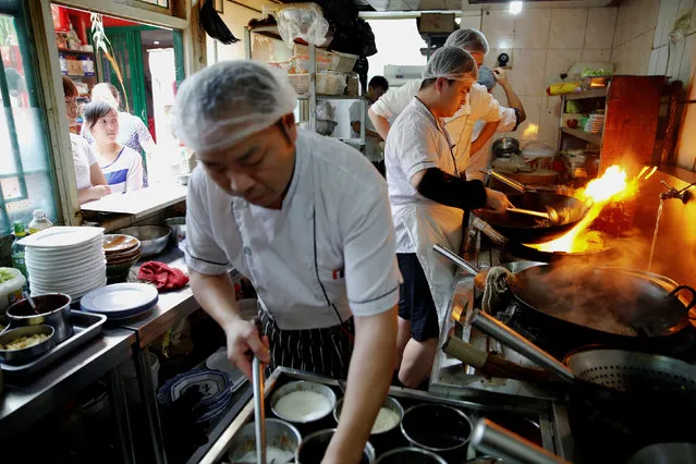 Staff of Zhenxiangfudi restaurant, whose manager plans to offer more beef and lamb meat dishes, if the pork price keeps rising, work at their kitchen in central Beijing, China May 18, 2016. (Photo by Damir Sagolj/Reuters)