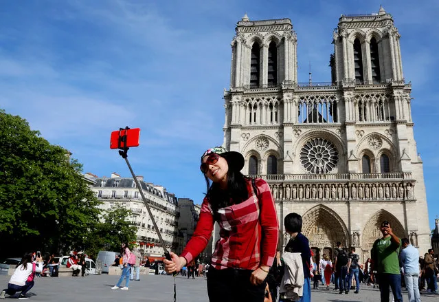 A chinese tourist takes a selfie in front of the Notre Dame Cathedral in Paris, France, May 5, 2016. (Photo by Jacky Naegelen/Reuters)