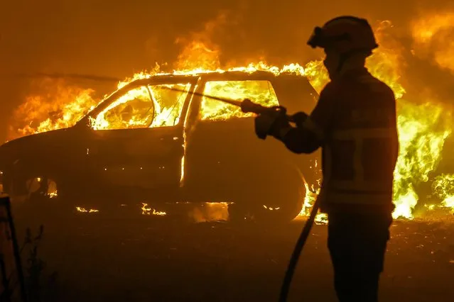 A Firefighter battles with a fire in Pampilhosa da Serra, central of Portugal, 18 June 2017. At least sixty two people have been killed in forest fires in central Portugal, with many being trapped in their cars as flames swept over a road on the evening of 17 June 2017. (Photo by Paulo Novais/EPA)