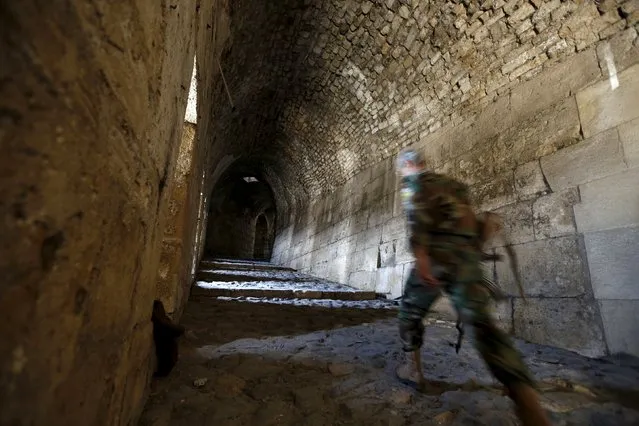 A Syrian army soldier walks inside the Crac des Chevaliers, a UNESCO World Heritage site, in the Homs countryside, Syria August 2, 2015. Syria's tourism minister Bishr Yazigi announced on Sunday the re-opening of the Crac des Chevaliers for tourists and the start of the al-Wadi festival. (Photo by Omar Sanadiki/Reuters)