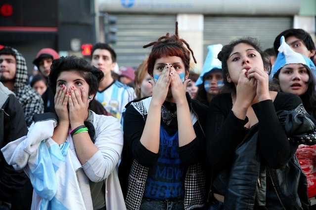Argentine soccer fans react while watching a television broadcast as time runs out against Germany during the World Cup final on July 13, 2014 in Buenos Aires, Argentina. (Photo by Joe Raedle/Getty Images)
