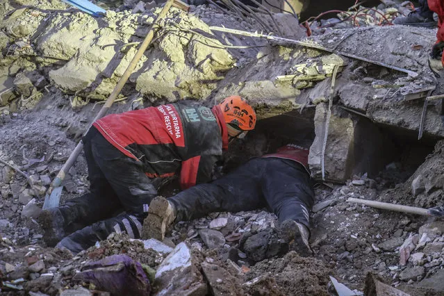 Rescue workers try to save people trapped under debris following a strong earthquake that destroyed several buildings on Friday, in Elazig, eastern Turkey, Sunday, January 26, 2020. Rescue workers were continuing to search for people buried under the rubble of apartment blocks in Elazig and neighboring Malatya. Mosques, schools, sports halls and student dormitories were opened for hundreds who left their homes after the quake. (Photo by Ismail Coskun/IHA via AP Photo)
