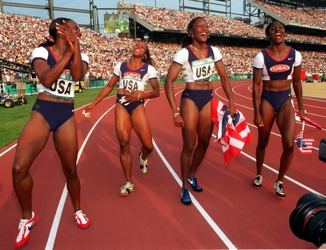 The United States women's 4x100 meters relay team' from left: Inger Miller, Gail Devers, Chryste Gaines and Gwen Torrence laugh during their victory lap after winning the gold at the 1996 Summer Olympic Games in Atlanta, Saturday August 3, 1996. (Photo by Amy Sancetta/AP Photo)