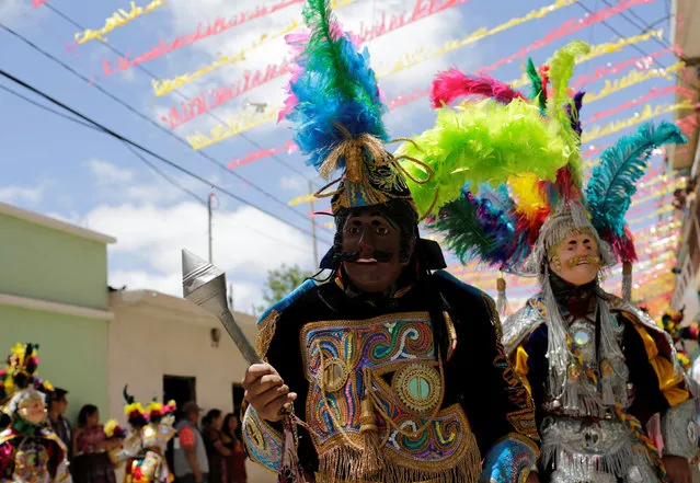 Dancers dressed for the annual procession honoring San Pedro, their town's patron saint, walk through the streets of San Pedro Sacatepequez, near Guatemala City June 29, 2016. (Photo by Saul Martinez/Reuters)