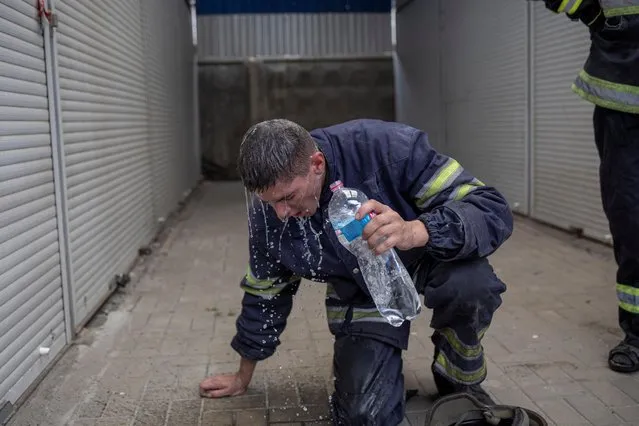 Firefighter tries to cool himself off after extinguishing a fire at a market after shelling, as Russia?s attack on Ukraine continues, in Sloviansk, Donetsk region, Ukraine, July 5, 2022. (Photo by Marko Djurica/Reuters)