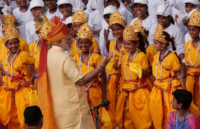 Prime Minister Narendra Modi greets school girls dressed as Hindu Lord Krishna, after addressing the nation from the historic Red Fort during Independence Day celebrations in Delhi, August 15, 2017. (Photo by Adnan Abidi/Reuters)