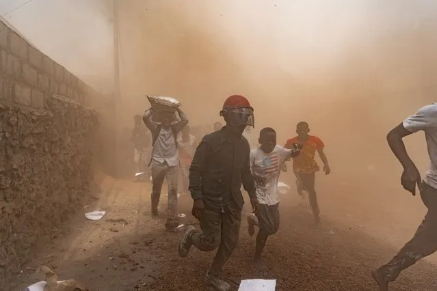 Looters flee the scene of a looted warehouse belonging to the peacekeeping mission in the Democratic Republic of Congo (MONUSCO) at the UN facilities in Goma on  July 25, 2022. Protesters stormed a United Nations base in the eastern Congolese city of Goma today, an AFP journalist said, demanding the departure of peacekeepers from the region. (Photo by Michel Lunanga/AFP Photo)