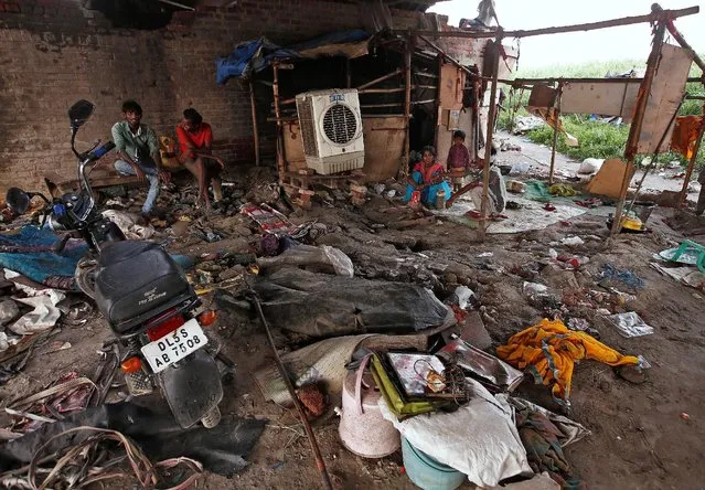 A family sits outside their makeshift home under a railway bridge over the river Yamuna in the old quarters of Delhi, India, July 19, 2016. (Photo by Adnan Abidi/Reuters)