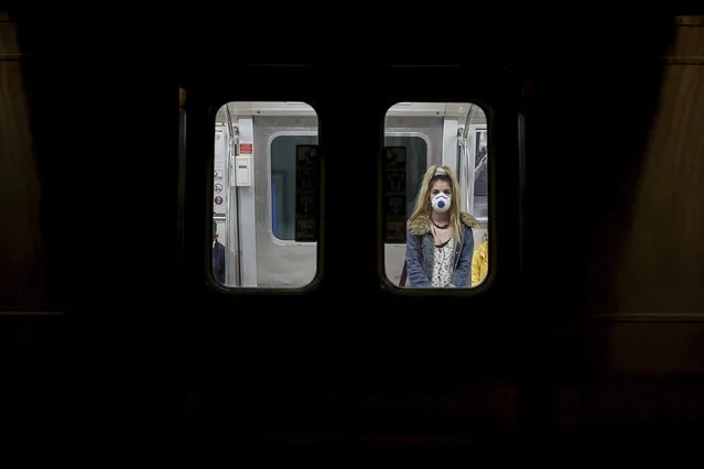 A commuter, wearing a mask as a preventive measure against the spread of the coronavirus, travels on a metro train in Istanbul, Friday, April 10, 2020. (Photo by Emrah Gurel/AP Photo)