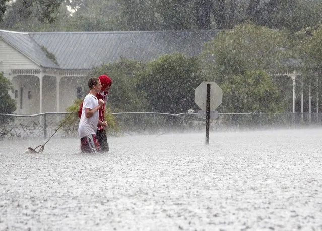 Residents of Mandeville, La., walk through a flooded street as Isaac passes through on Aug. 30. (Photo by Jonathan Bachman/Reuters)