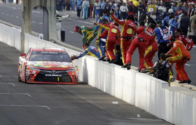 Kyle Busch celebrates with his crew after winning the Brickyard 400 NASCAR Sprint Cup auto race at Indianapolis Motor Speedway in Indianapolis, Sunday, July 24, 2016. (Photo by Darron Cummings/AP Photo)